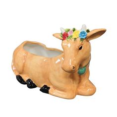 a ceramic animal planter with flowers on it's head and legs, laying down