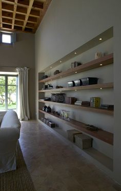 a bedroom with open shelves on the wall and sliding glass doors that lead to an outside patio