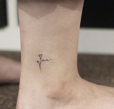 a small flower tattoo on the ankle