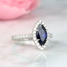 Gorgeous Vintage Inspired Marquise Royal Blue Sapphire Ring ►Made of solid sterling silver with rhodium finish (925) ►Accented With Simulated Diamonds (CZ) ►Average band width: 1.9 mm Center Stone: Sapphire Color: Royal Blue Shape: Marquise Gem size: 5.0x 10.0 mm Average Carat Weight: 0.95 ct. Gemstone creation: 100% Genuine Lab-Grown Hardness: 9-9.5 (Mohs scale) ✓ 100% Nickel-Free ✓ Hypoallergenic ✓ Comfort Fit ✓ Free Ring Box ✓ Free USA Shipping Classic Marquise Sapphire Ring For Wedding, Classic Sapphire Ring With Marquise Cut, Classic Sapphire Marquise Cut Ring, Classic Marquise Birthstone Promise Ring, Classic Marquise Cluster Ring Gift, Sapphire Marquise Ring With Center Stone, Marquise Cut Sapphire Ring With Halo Setting As Gift, Gift Sapphire Ring With Prong Setting In Marquise Cut, Gift Sapphire Ring Marquise Cut With Prong Setting