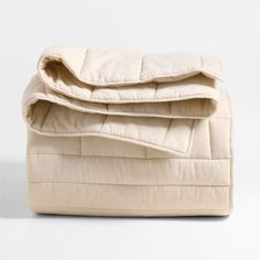 an unmade blanket folded on top of each other with the cover pulled up to show it's inner structure