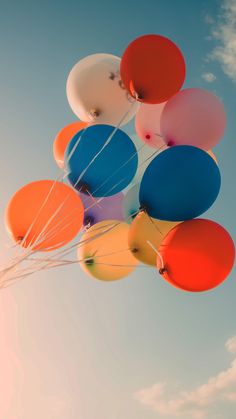 a bunch of balloons floating in the air