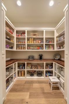 an organized pantry with white shelves and wooden flooring