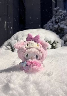 a small stuffed pig sitting in the snow