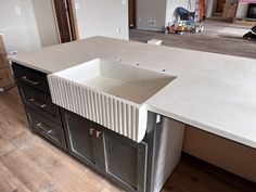 a kitchen counter with a sink in the middle and cabinets on either side that are being built