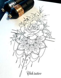 a pen and some ink on top of a piece of paper with flowers in it