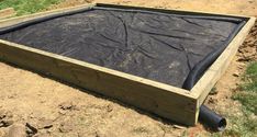 a large wooden box sitting on top of a dirt field