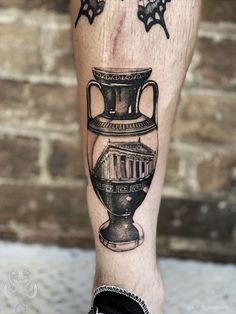 a man's leg with a vase tattoo on it