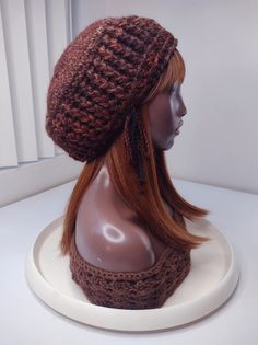 a mannequin head wearing a knitted hat on top of a white table