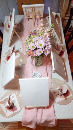 the table is set with pink flowers and place settings for an afternoon tea party or brunch