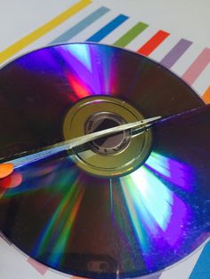 a person holding a cd in their right hand and pointing it at the disc on the other side