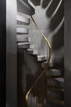 a spiral staircase in a building with concrete walls