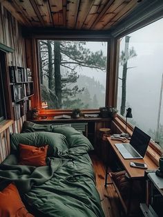 a bed sitting in a bedroom under a window next to a desk with a laptop on it