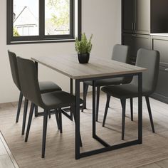 a dining room table with four chairs and a potted plant on the table in front of it