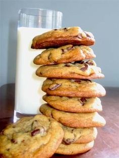 a stack of chocolate chip cookies next to a glass of milk