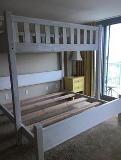 a wooden bunk bed sitting in a bedroom next to a sliding glass door