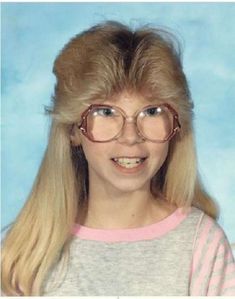 an old photo of a woman with glasses on her head and long blonde hair, smiling at the camera