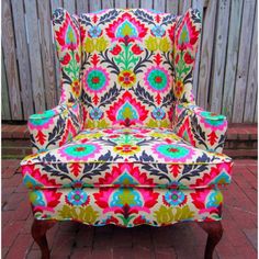 a colorful chair sitting on top of a brick floor