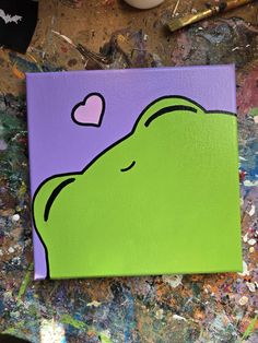 a green frog with a heart painted on it