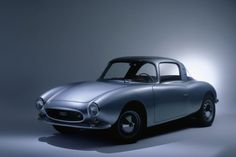 an old silver sports car in the spotlight