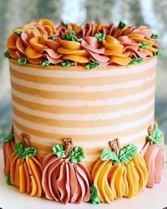 a decorated cake with pumpkins and leaves on it