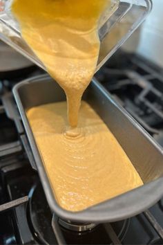 someone pouring batter into a pan on top of an oven with other items in it