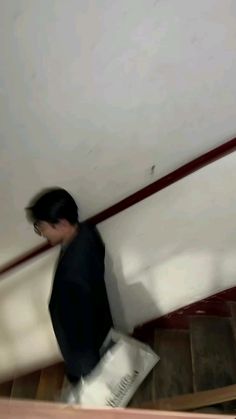 a blurry image of a man walking up some stairs with a bag in his hand