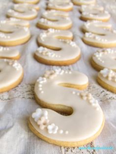 a table topped with lots of white frosted doughnuts covered in icing