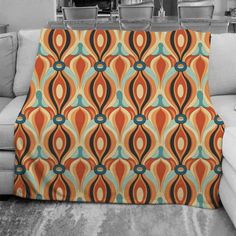 an orange and blue throw blanket sitting on top of a couch