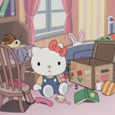 hello kitty sitting on the floor in front of an open box and stuffed animal toys