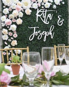 the table is set with wine glasses and flowers