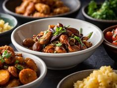 several bowls filled with food on top of a black countertop next to rice and veggies