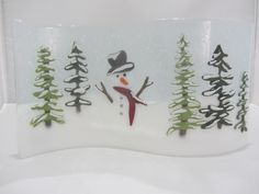 a frosty glass snowman with trees in the background