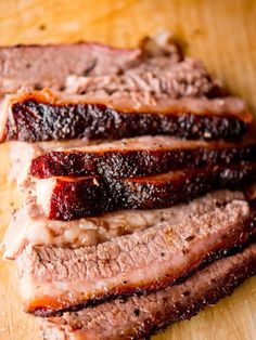 sliced meat sitting on top of a wooden cutting board