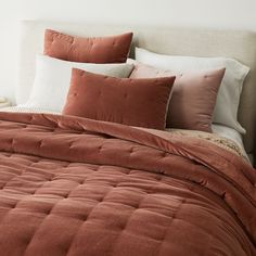 a bed with orange and white pillows on top of it