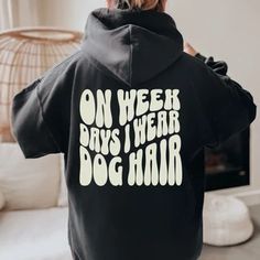 the back of a person wearing a black hoodie that says on week, boys i wear dog hair