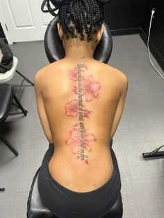 a woman sitting in a chair with her back turned to the camera and tattoos on her body