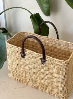 This gorgeous handmade straw bag by Maz Argan is perfect for any occasion. Its boho style and lightweight design make it ideal for travel, weddings, parties, or casual use. The bag is small in size, measuring 32cm in width, 21cm in depth, and 22cm in height,and features a wristlet for easy carrying. The bag's exterior is woven straw in a beige colour, while the lining is also made of straw in a complementary beige shade. The bag is not only stylish but also eco-friendly, as it's made from sustainable materials. It's a limited edition product, so you won't find it anywhere else. Whether you're hitting the beach or shopping in the city, this bag is the perfect accessory to complete your look. Small  22cm height  32cm width Medium  26cm height 38cm width Bohemian Straw Bag With Woven Leather In Natural Color, Natural Rectangular Beach Bag With Leather Handles, Bohemian Beige Beach Bag With Woven Leather, Chic Open Weave Straw Bag For Market, Bohemian Beige Leather Woven Beach Bag, Rectangular Straw Bag With Leather Handles For Beach, Bohemian Rectangular Straw Bag With Woven Leather, Bohemian Brown Straw Bag For Market, Bohemian Woven Leather Beach Bag In Natural Color