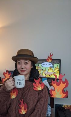 a woman wearing a hat and holding a coffee mug