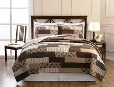 a bed with a brown and white quilt on it