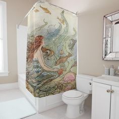 there is a bathroom with a mermaid shower curtain on the wall and a toilet next to it