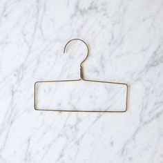 a pair of metal clothes hangers on a marble surface