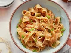 a bowl filled with pasta and sauce on top of a table