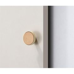 a door knob with a wooden button on it's side next to a white wall