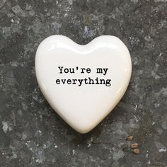 a ceramic heart with the words you're my everything on it sitting on a stone surface