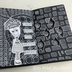 an open book with black and white designs on it, which is part of a coloring book