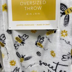 a towel with bees on it and the words oversize throw written in black ink