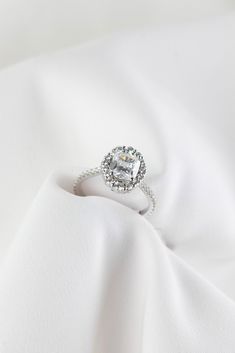 a diamond ring sitting on top of a white cloth