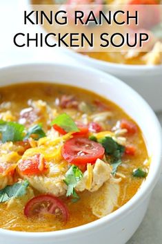 a bowl of chicken soup with tomatoes and spinach on top, in front of another bowl