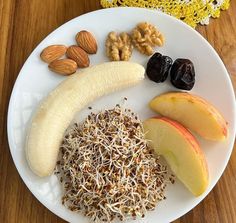 a white plate topped with fruit and nuts